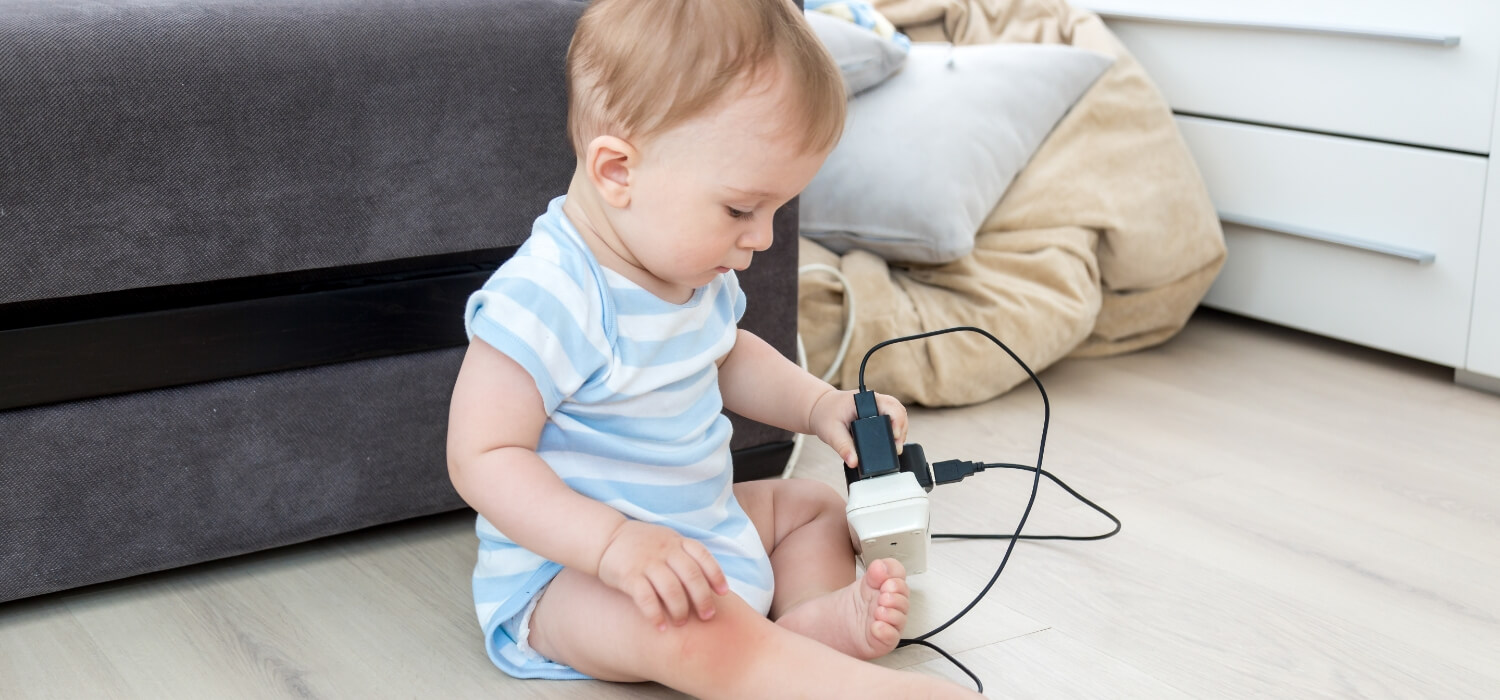 baby playing with strip surge protector