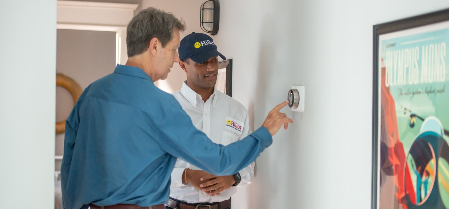 technician performing ac maintenance on thermostat