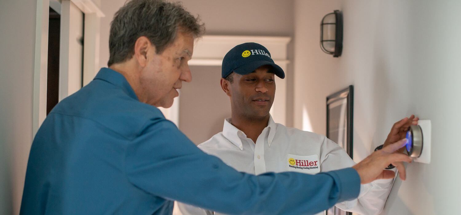 technician helping customer with learning thermostat