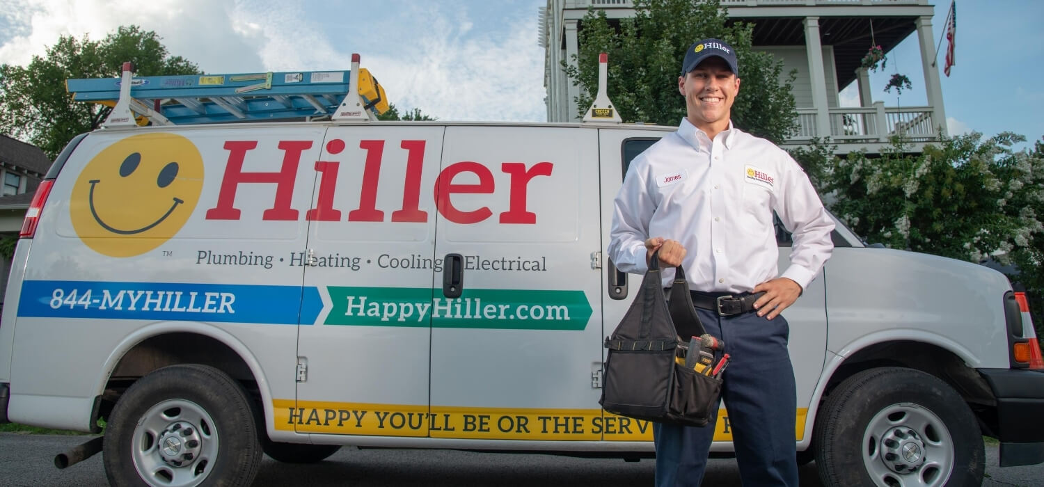 technician holding toolbag in front of van