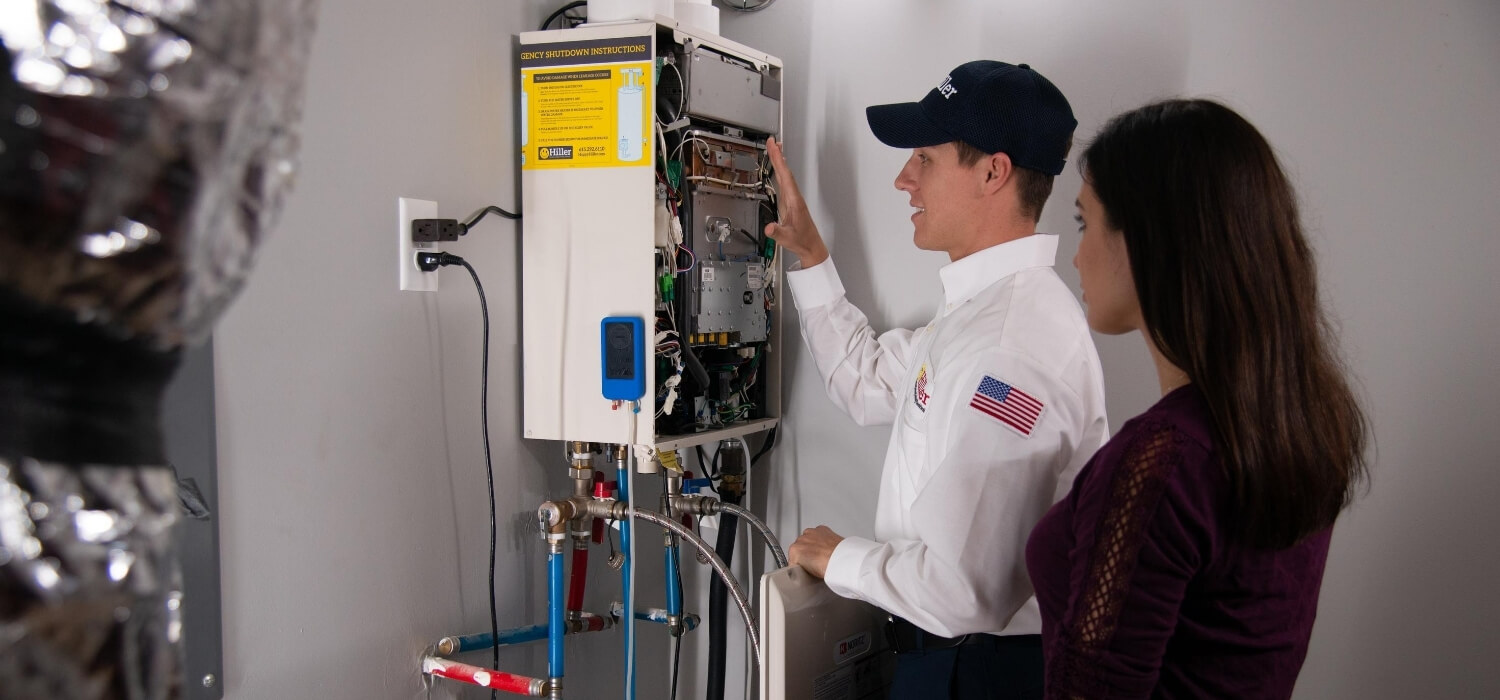 technician performing plumbing maintenance check on tankless water heater