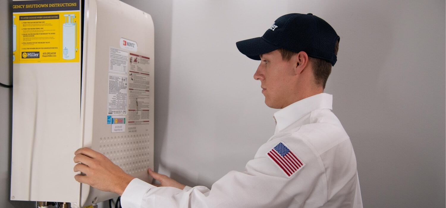 technician performing maintenance on tankless water heater