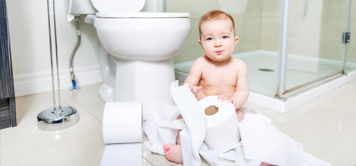 baby with toilet paper in bathroom floor