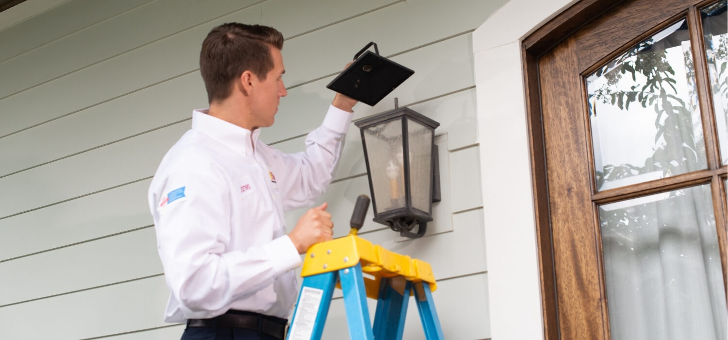 Hiller technician fixing exterior light