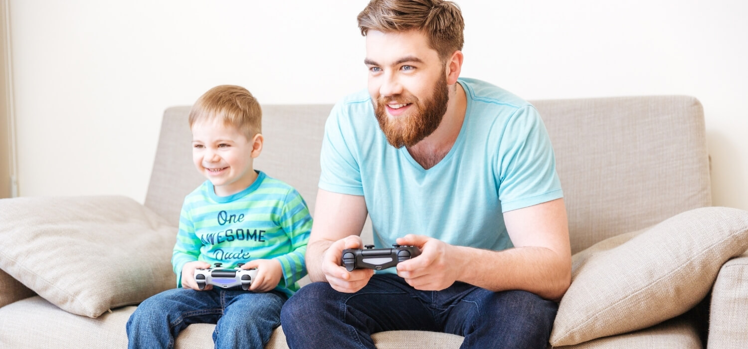 dad and son playing video games on couch