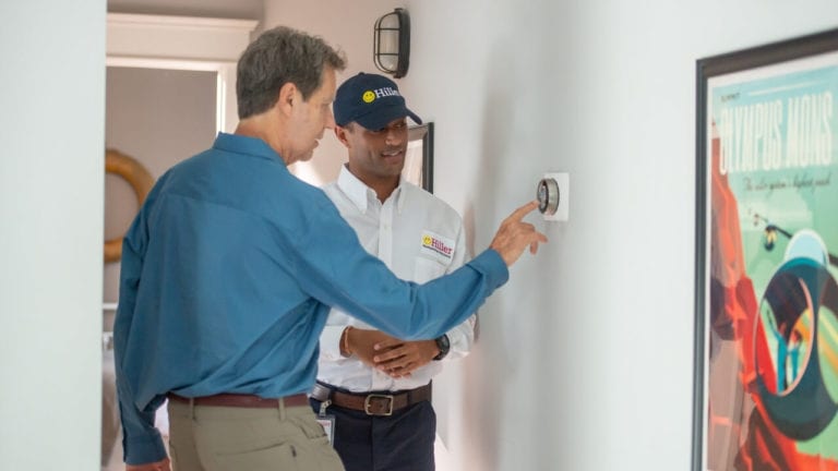 HVAC technician Showing Customer Nest Learning Thermostat