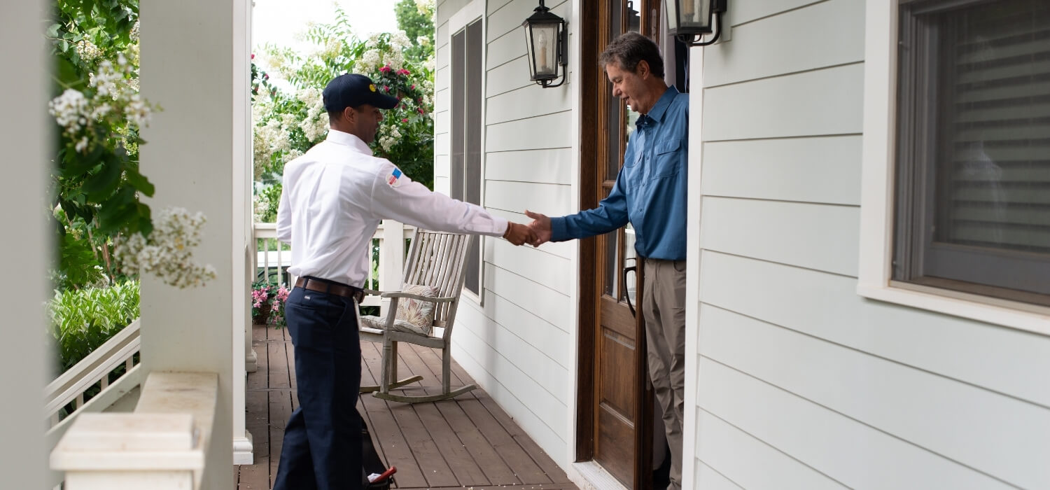 HVAC Technician Greeting Customer at Front Door