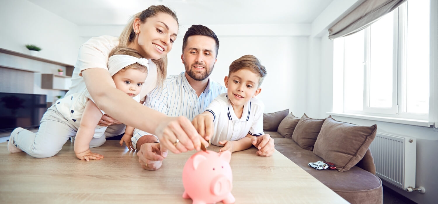 Family Inserting Coins into Piggy Bank