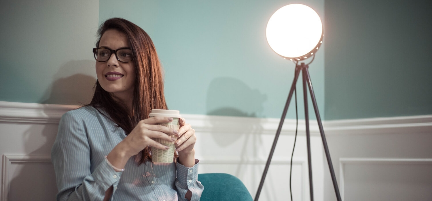 Lady Drinking Coffee Beside Ambient Lighting